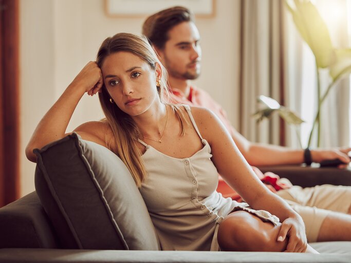 Paar sitzt zerstritten auf dem Sofa | © AdobeStock/Kay Abrahams/peopleimages.com