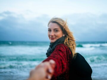 Freie Frau am Meer an der Hand ihres Partners. | © Getty Images/Westend61