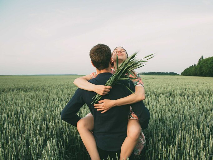 Pärchen im Feld mit Brautstrauß aus Korn. | © Getty Images/Iuliia Bondar