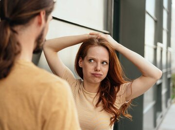 Junge Frau blickt mit genervtem Blick auf ihren Partner. | © Getty Images/stockfour