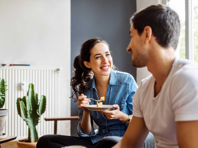 Frau blickt einen Mann beim Date positiv überrascht an. | © Getty Images/Luis Alvarez