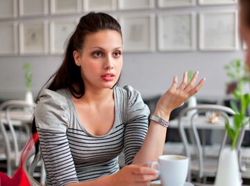 Junge Frau im Café redet ohne vorher zu denken. | © Getty Images/Henglein and Steets