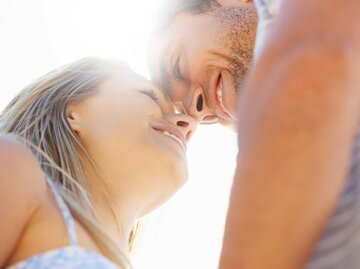 Foto von unten, nimmt Frau und Mann auf, wie sie sich verliebt fast Küssen. | © Adobe Stock/Nicola Katie/peopleimages.com