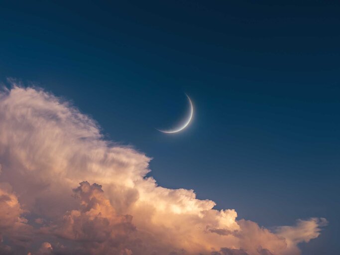 Neumond am Himmel mit Wolken bei Sonnenuntergang. | © Getty Images/Nazarii Neshcherenskyi