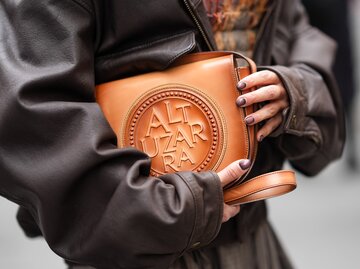 Model mit braunen Fingernägeln trägt eine braune Handtasche | © GettyImages/Edward Berthelot