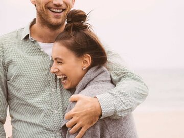 Glückliches Paar lacht zusammen am Strand | © Getty Images/Jacobs Stock Photography Ltd