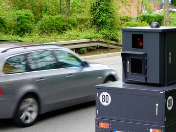 Ein Auto fährt an einem Blitzer vorbei. | © Adobestock/Karsten