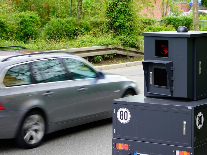 Ein Auto fährt an einem Blitzer vorbei. | © Adobestock/Karsten