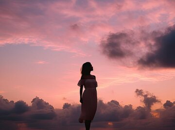 Frau steht vor pinkem Himmel | © Adobe Stock/irissca/KI generiert