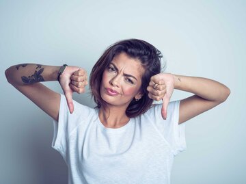 Frau macht ein verärgertes Gesicht und Daumen runter | © Getty Images/izusek