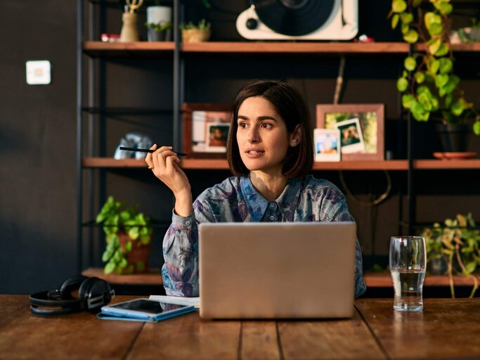 Person sitzt an Schreibtisch | © Getty Images/10'000 Hours