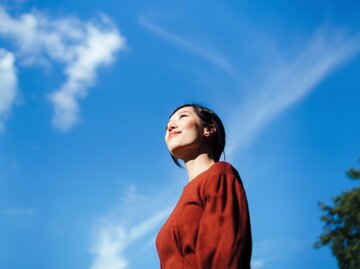 Introvertierte Frau steht draußen bei blauem Himmel | © GettyImages/d3sign