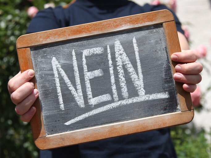 Person mit Nein-Schild | © Getty Images/Bjoern Wylezich