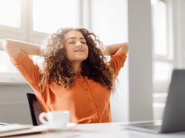 Junge Frau in orangem Pullover macht Pause vor dem Laptop | © AdobeStock/Prostock-studio