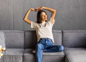 Frau sitzt auf dem Sofa und entspannt