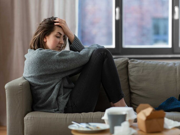 Frau sitzt auf dem Sofa und ist traurig | © Adobe Stock/Syda Productions