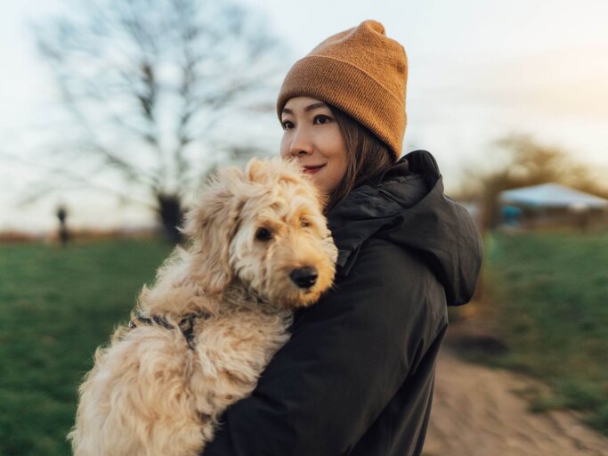 Person mit Hund auf Armen | © Getty Images/Oscar Wong