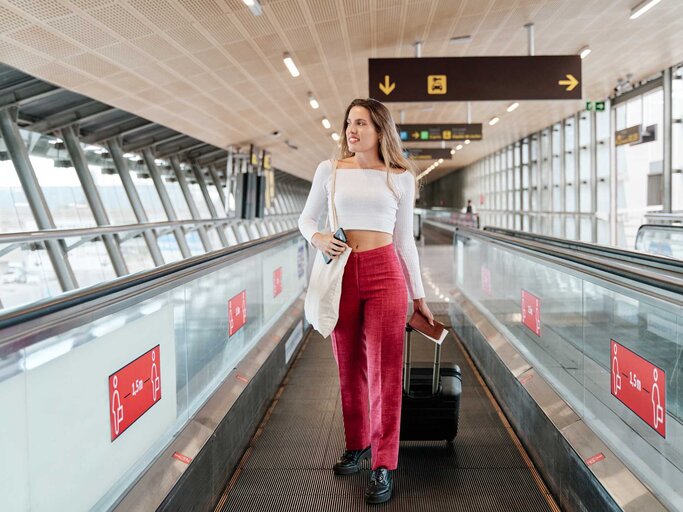 Frau mit roter Hose am Flughafen | © Getty Images/Alvaro Medina Jurado