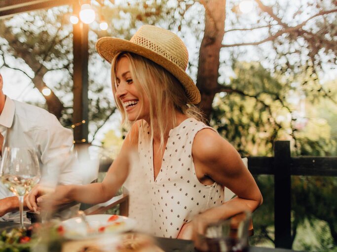 Junge Frau isst im Urlaub glücklich im Restaurant. | © Getty Images/AleksandarNakic