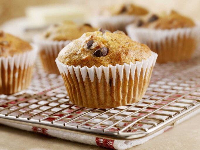 Eine gebackener Muffin mit Schokoflocken auf einem Backblech | © Getty Images/LauriPatterson