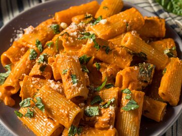 Ein Close-up von Pasta in cremiger roter Sauce mit Parmesan | © Getty Images/bhofack2