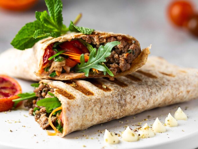 Zwei Hälften Crunch Wrap mit frischen Kräutern garniert | © Getty Images/Elizaveta Bauer