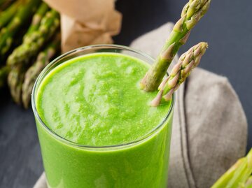 grüner Spargel-Smoothie mit zwei Spargelstangen garniert, von oben fotografiert | © Getty Images/Metkalova