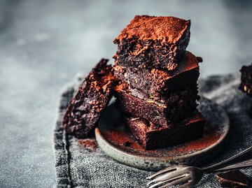 Zucchini-Kuchen Stücke auf einem Teller mit zwei Gabeln daneben | © GettyImages/alvarez