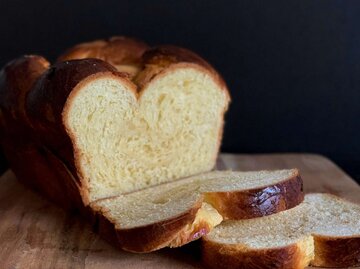 Ein Brioche Brot vor schwarzem Hintergrund | © unsplash/Youjeen Cho