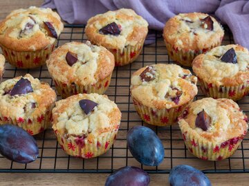 Pflaumenmuffins und Pflaumen auf einem Backblech | © Adobe Stock/AndreaR