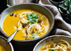 Drei Schüsseln Curry Suppe auf einem Holztisch, Nahaufnahme