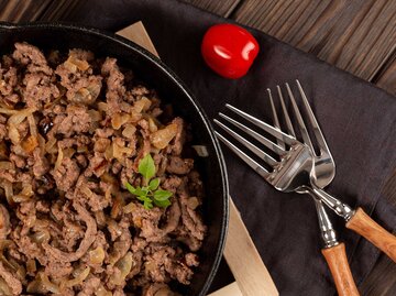 Hackfleisch gebraten mit Zwiebeln und Gewürzen in einer gusseisernen Pfanne, Omas "Haschee" Rezept | © Getty Images/Natalya Ugryumova