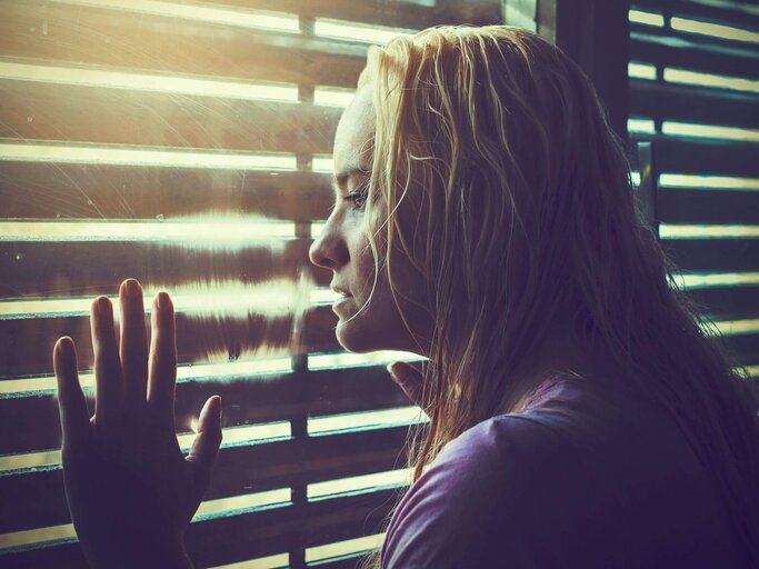 Person schaut aus dem Fenster | © Getty Images/MarinaZg