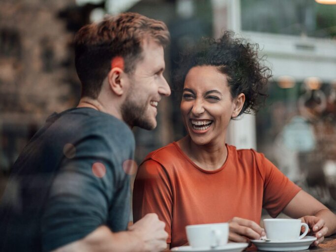 Zwei Personen lachen beim Kaffeetrinken | © Getty Images/Westend61