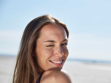 Junge Frau am Strand flirtet mit der Kamera. | © Getty Images/Westend61