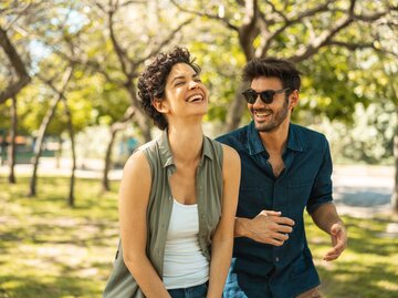 Frau lacht bei einem Date mit einem Mann | © Getty Images/MesquitaFMS