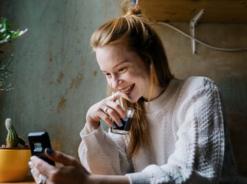 Person lacht und schaut auf Handy | © Getty Images/Willie B. Thomas