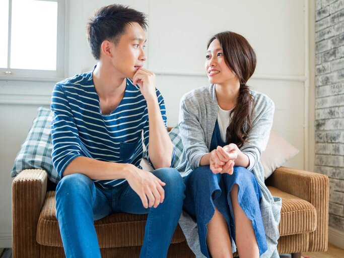 Mann und Frau unterhalten sich auf Couch. | © Getty Images/Indeed