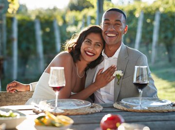 Hochzeitspaar an Tisch | © Getty Images/Klaus Vedfelt