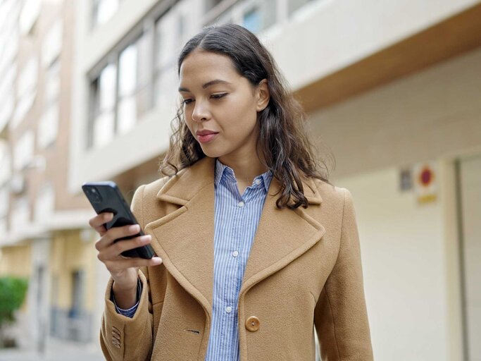 Frau schaut auf ihr Handy | © Adobe Stock/Krakenimages.com