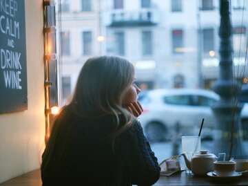 Nachdenkliche Frau im Cafe schaut aus dem Fenster | © Adobe Stock/Vladimir