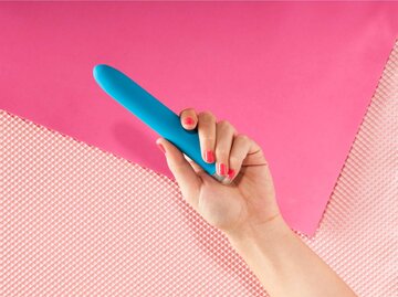 Vibrator in der Hand einer Frau vor pinkem Hintergrund. | © Getty Images/Megan Madden/Refinery29