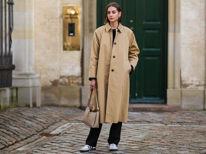 Frau mit Trenchcoat und Flared Yoga Pants | © Getty Images/ Edward Berthelot