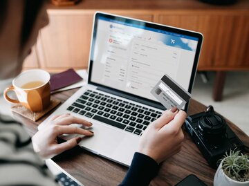 Frau sitzt mit ihrer Kreditkarte vor dem Laptop | © Getty Images/d3sign