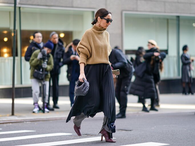 Streetstyle von Frau, die Plisseerock über Hose trägt | © Getty Images/Edward Berthelot