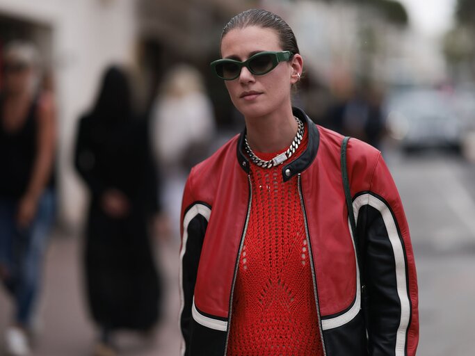 Streetstyle von Frau in roter Bikerjacke und rotem Kleid | © Getty Images/Jeremy Moeller