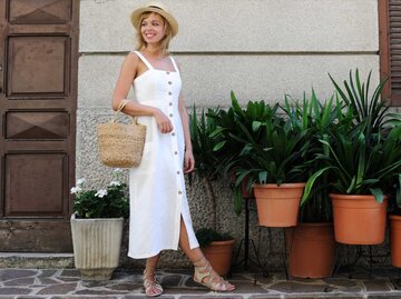 Frau in weißem Sommerkleid mit Hut | © Getty Images/lenta