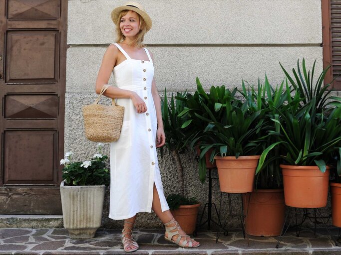 Frau in weißem Sommerkleid mit Hut | © Getty Images/lenta