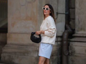 Frau trägt einen beigen Sweater, eine weiße Sonnenbrille und blaue Shorts | © Getty Images/Jeremy Moeller
