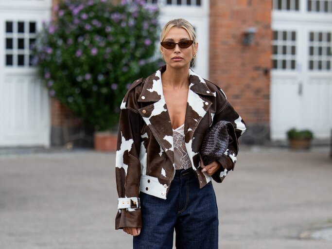 Streetstyle von blonder Frau mit Kuhprint-Jacke und Jeans. | © Getty Images/Christian Vierig